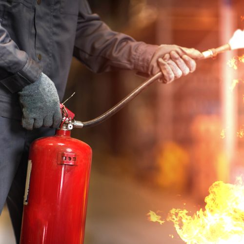 Man,Using,Fire,Extinguisher,Fighting,Fire,Closeup,Photo.